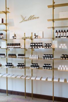 the shelves are filled with bottles of different types of perfumes in gold and white