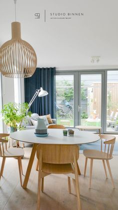 a dining room table with chairs and a lamp in the middle, next to an open patio door