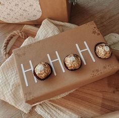 three chocolates sitting on top of a brown box next to a christmas ornament