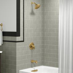 a white bath tub sitting next to a shower with two faucets on it