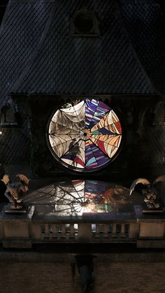 a stained glass window on top of a wooden table in front of a dark building