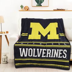 a black and yellow blanket sitting on top of a white couch