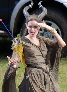 a woman dressed in costume with horns on her head and hands out to the side