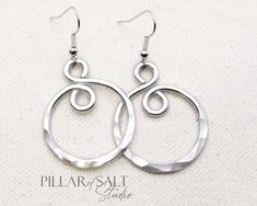 These handcrafted earrings are super light and just might become your new go-to pair. These shiny and lightweight earrings were handcrafted from thick aluminum wire, hammered for that great texture that catches the light, and then tumbled for greater shine and strength. The ear wires are solid stainless steel. They hang about 1 3/4" from the piercing (the spiral itself is about 1 1/4" long) and are approximately 1" wide. The pair you receive will vary slightly from the pair in the photos due to the handmade nature but will be very similar. Seriously lightweight, and seriously shiny!! * Aluminum (10th anniversary gift). * Stainless steel ear wires. * Lightweight. * Length: 2" from the piercing. Please don't hesitate to ask questions. Wire Bracelets Diy, Hammered Wire Jewelry, Aluminum Wire Jewelry, Jewelry Hacks, Aluminum Earrings, Infinity Earrings, 10th Anniversary Gifts, Hammered Jewelry, Wire Wrap Jewelry Designs