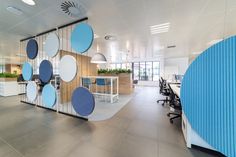 an office with blue and white circles hanging from the wall, along with two desks