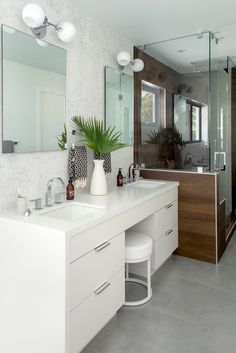 a large bathroom with two sinks and mirrors