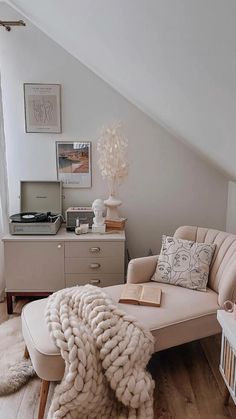 a living room filled with furniture and a blanket on top of a couch next to a window