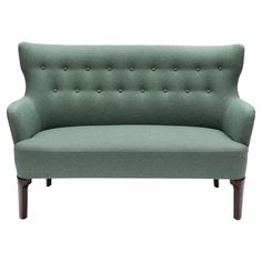 a green couch sitting on top of a wooden frame