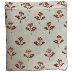 a red and white pillow with leaves on it