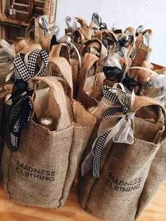 burlap bags with black and white bows are stacked on top of each other