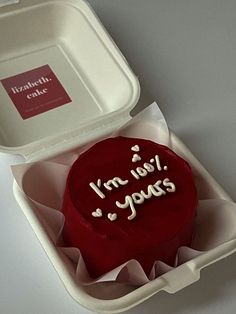 a red cake in a white box with writing on it