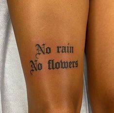 a woman with a tattoo on her leg that says no rain, no flowers written in cursive font