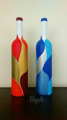 two colorful bottles sitting on top of a table next to each other, one with an abstract design