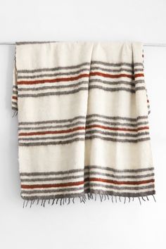 Queen sized ecru wool blanket with rows of horizontal grey and dark red stripes and a row of tied tassels at each end Bed Weather, Anthropologie Bedding, Wool Products, Blanket Craft, Bohemian Bedding, Unique Bedding, Unique Beds, Couch Throws, Organic Matter