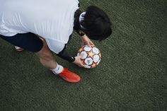 a man is holding a soccer ball on the grass