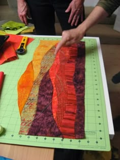 a person is cutting fabric on a table