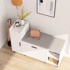 a small white bench with an umbrella and purse on it next to a wall mounted clock