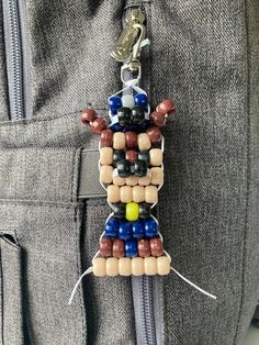 a keychain made out of beads is hanging from the pocket of a man's pants