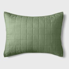 a green pillow on a white background with an image of a quilted square pattern