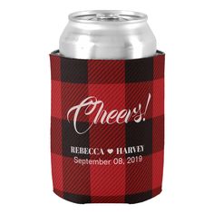 a red and black plaid can cooler with the words cheers on it, sitting next to a