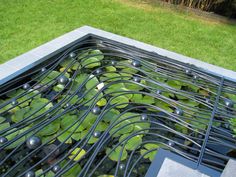 a pond filled with lots of water lilies next to a lush green park area