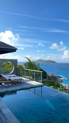 an outdoor swimming pool with chaise lounges overlooking the ocean