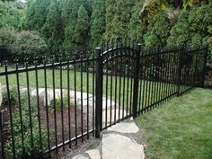 a black iron fence in the middle of a yard