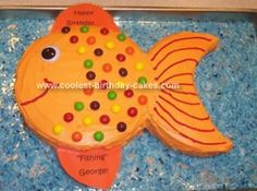 a cake shaped like a fish with candy on it's head and eyes in the shape of a fish