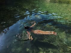 a person swimming in the water with their arms up