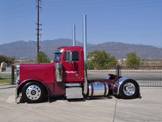 a red semi truck parked in a parking lot