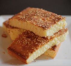 three pieces of cake sitting on top of a white plate with sesame seed sprinkles