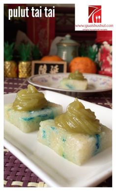 two small pieces of food on a white plate with blue and green icing in the middle