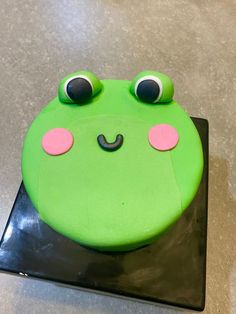 a green frog cake with eyes and nose