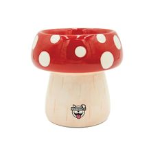 a red and white mushroom shaped vase with polka dots on the top, sitting in front of a white background