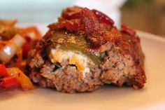 a close up of food on a plate with vegetables and meatloaf in the background