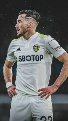 a soccer player standing in the rain with his hands on his hips