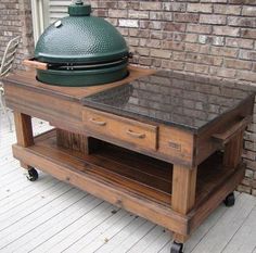 a big green egg sitting on top of a wooden cart