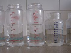 four jars with measuring labels on them sitting on a counter