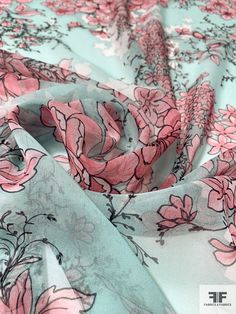 the fabric has pink flowers on it and is very light blue with pink trims