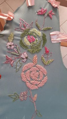 a blue apron with pink and green flowers on it