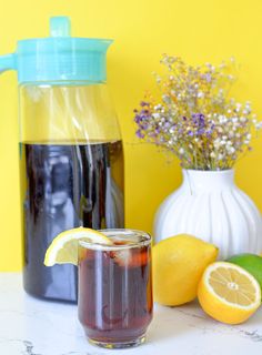 a pitcher of tea next to some lemons