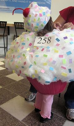 a child dressed up as a sheep with a number on it's back and head