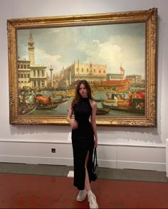 a woman standing in front of a painting