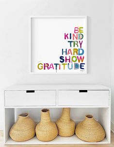 three vases are sitting on a shelf in front of a framed art print that says be kind try hard show gratitue