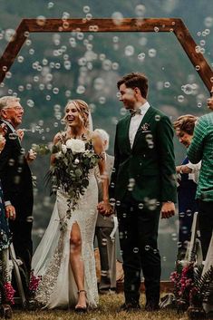 a bride and groom walk down the aisle as bubbles fly around them