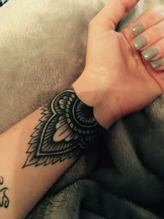 a woman's arm with a black and white hendike tattoo on it