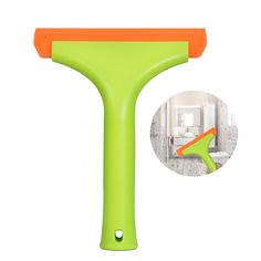 an orange and green spatula is shown with the image of a bathroom in the background