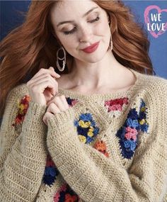 a woman with long red hair wearing a sweater and earrings is posing for the camera