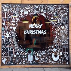 a merry christmas window is decorated with doodles