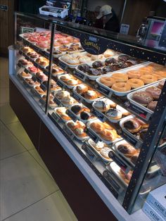 a display case filled with lots of different types of doughnuts and pastries